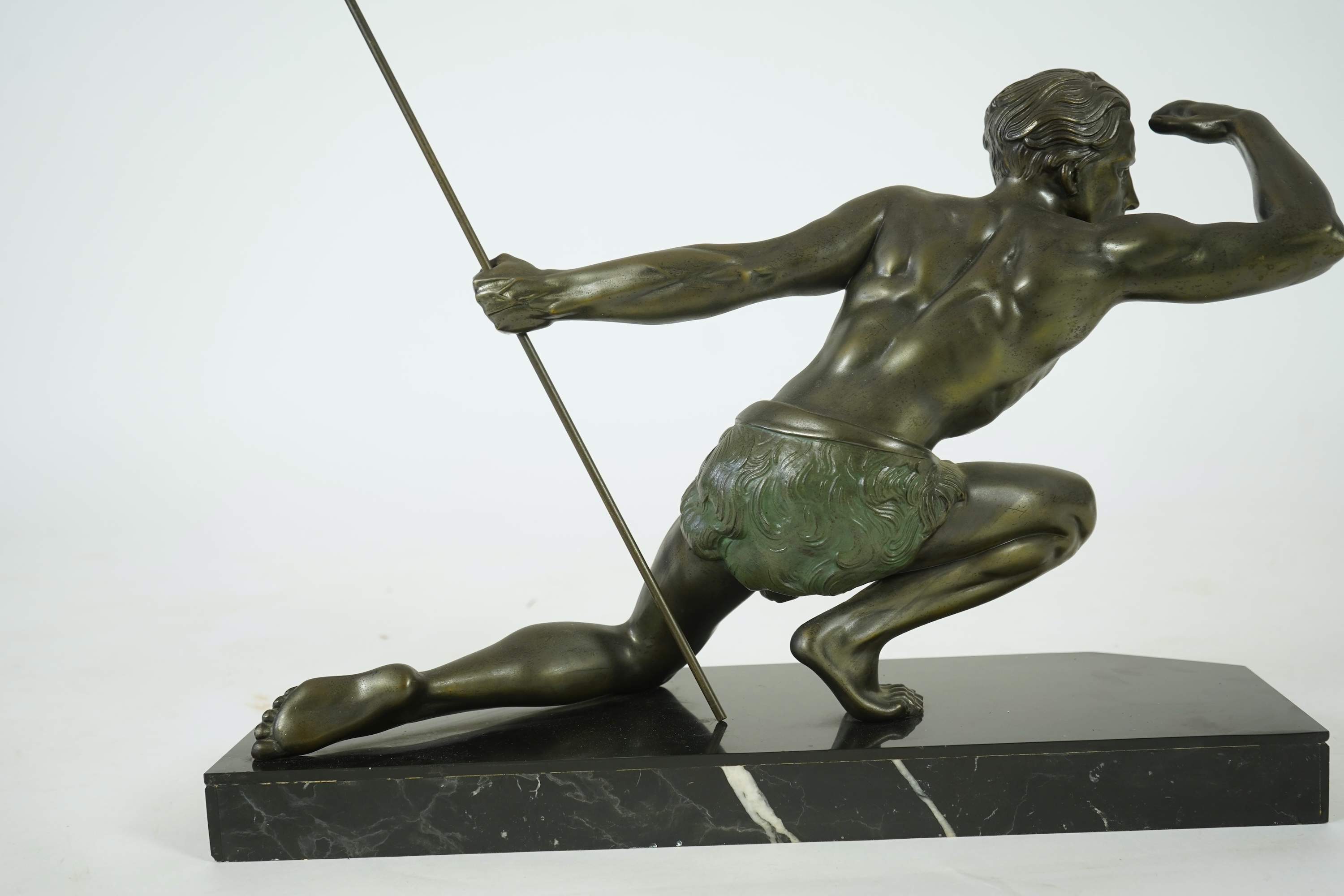 Manner of Jean de Roncourt (1869-1937) An Art Deco patinated bronze sculpture of a male hunter with spear on black marble stand